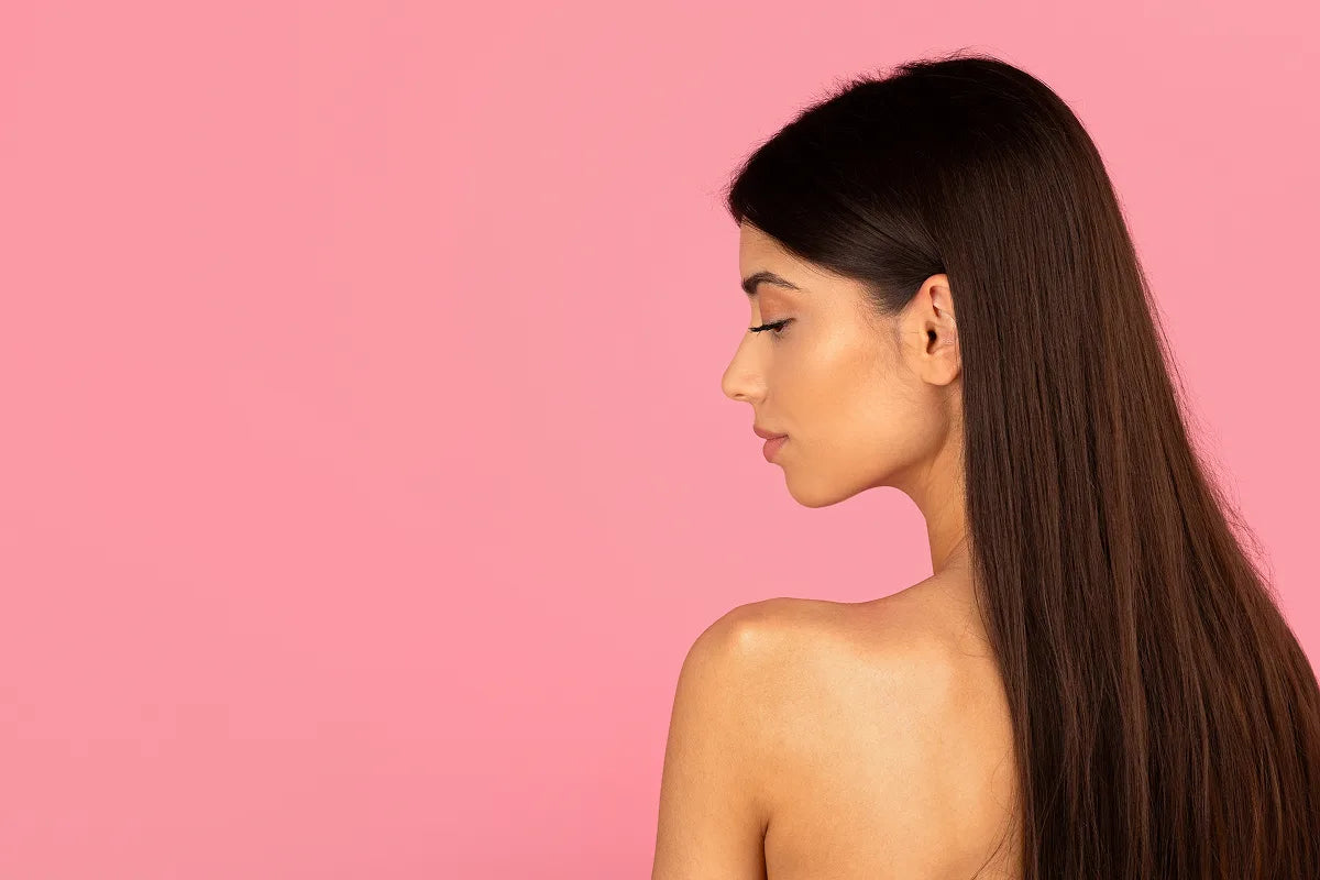 Side profile of a young woman with long dark hair showing a smooth, defined jawline and neckline, illustrating the goal of non-surgical double chin treatment