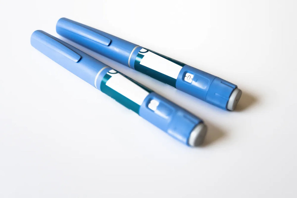 Two unbranded GLP-1 injection pens with caps on against a white background