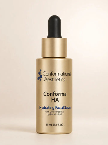 Conformational Aesthetics Conforma HA Hydrating Facial Serum in a 30 mL gold dropper bottle with a black rubber bulb and gold collar, set against a solid light beige background.