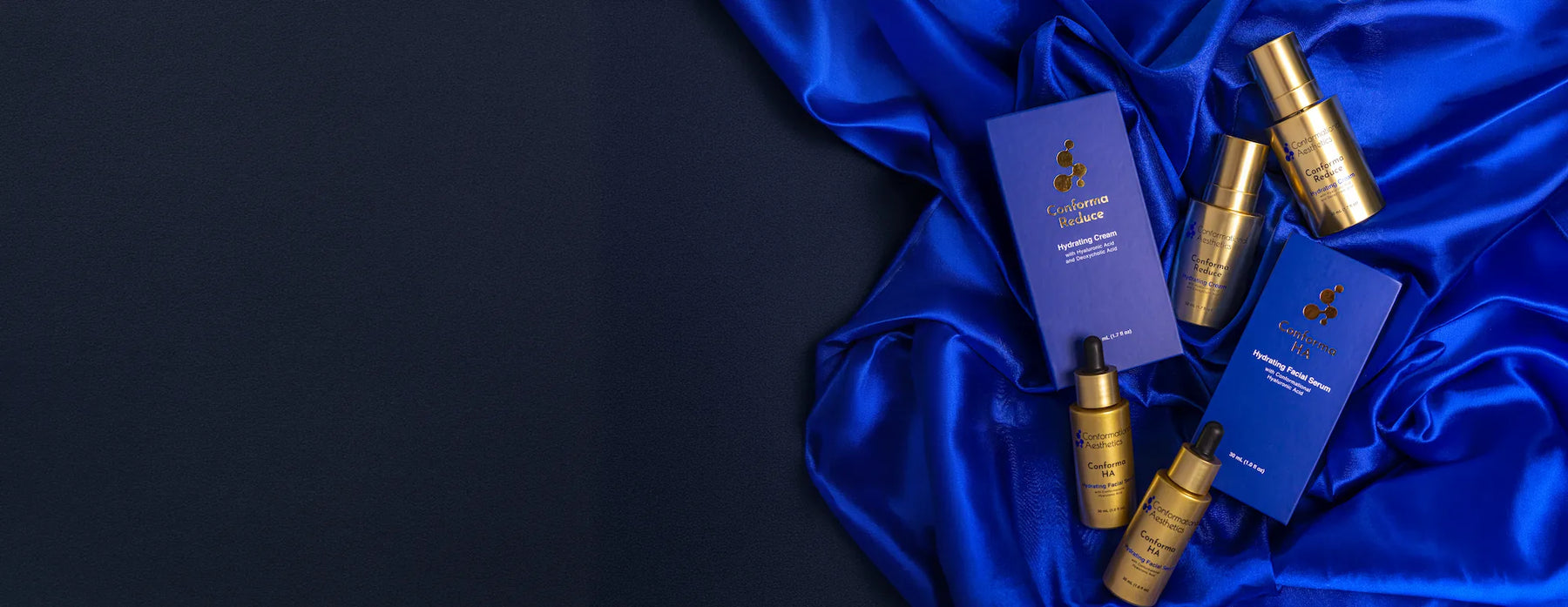 Conforma Reduce and Conforma HA blue boxes and gold bottles with blue silk sheets on bottom