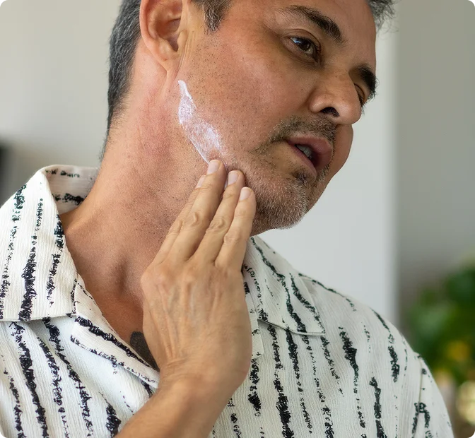 Man applying Conforma Reduce cream along his jawline and under his chin