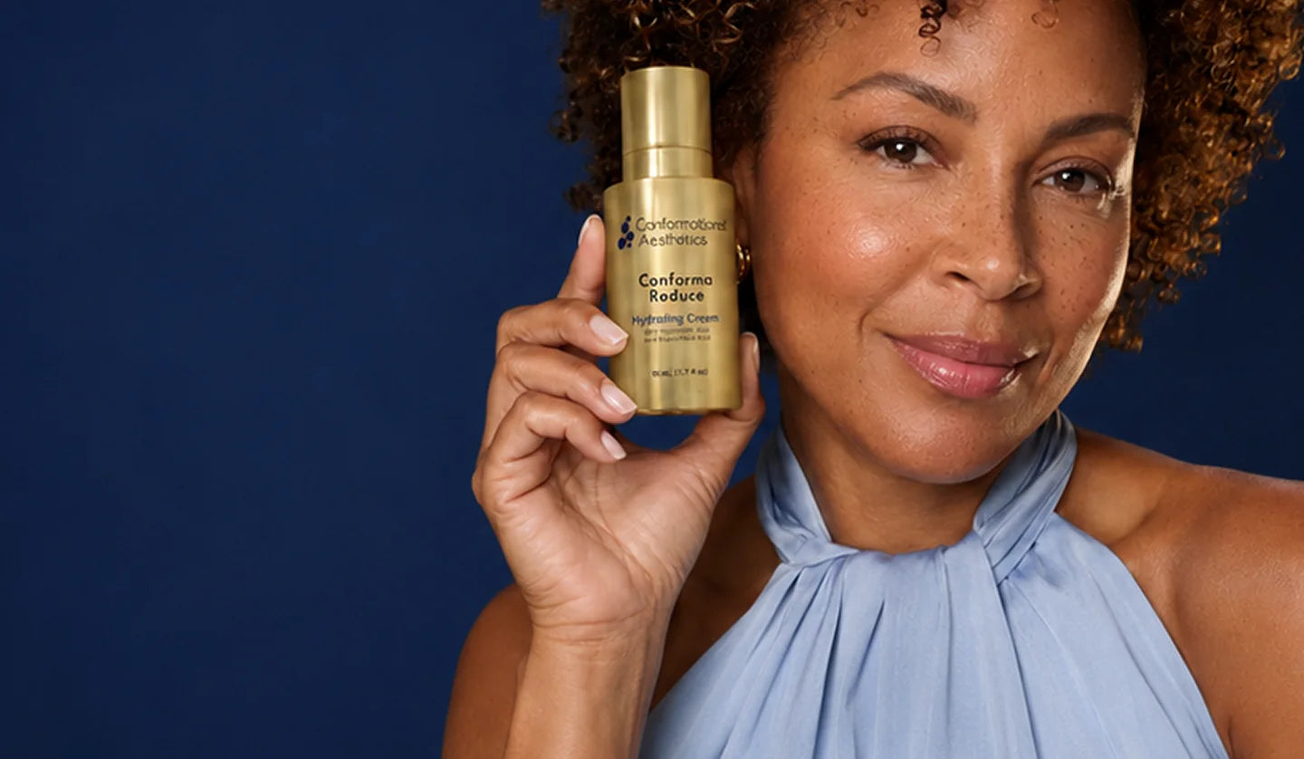 Woman holding a bottle of Conforma Reduce beside her face